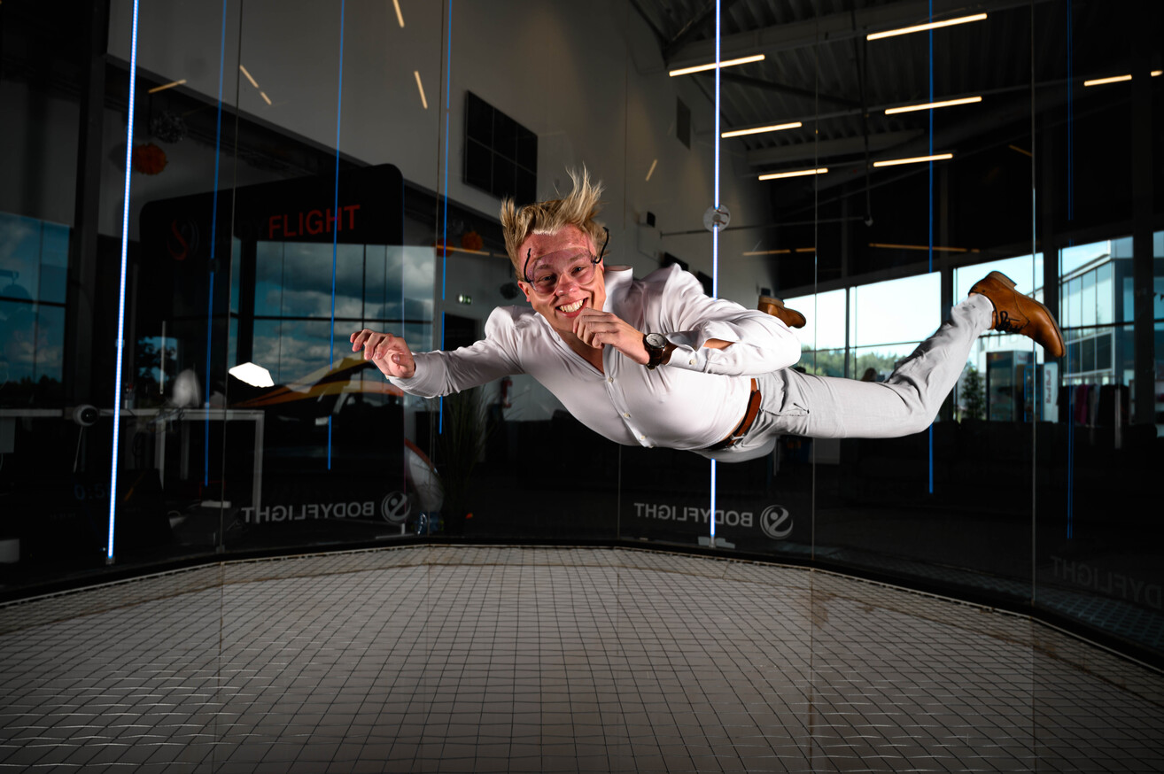En kvinna som testar på indoor skydiving bland roliga övningar konferens.