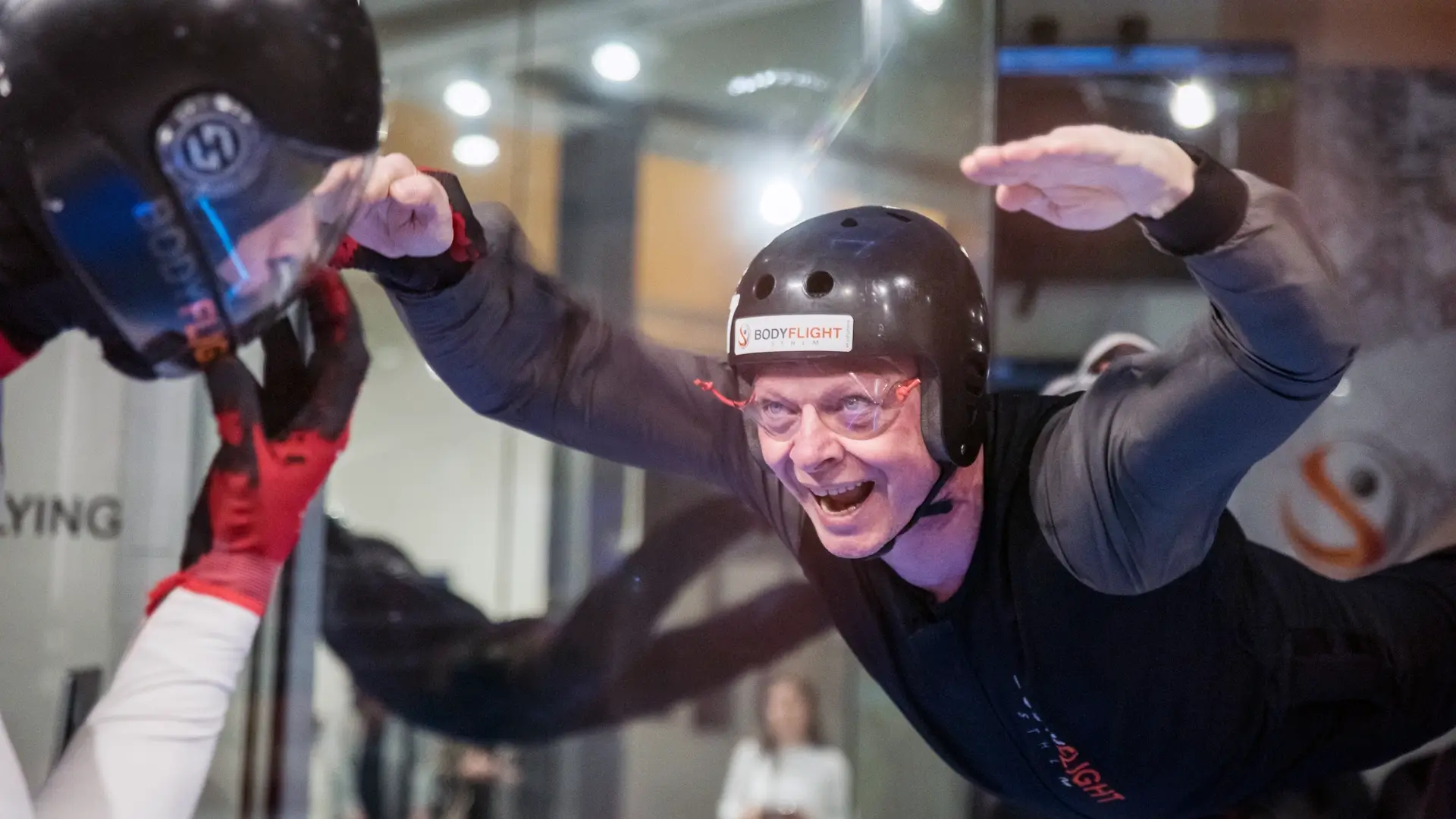 En äldre pappa som fått indoor skydiving som fars dag present.