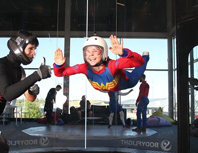 Kvinna som utför indoor skydiving, en av många roliga aktiviteter för vuxna i Stockholm.