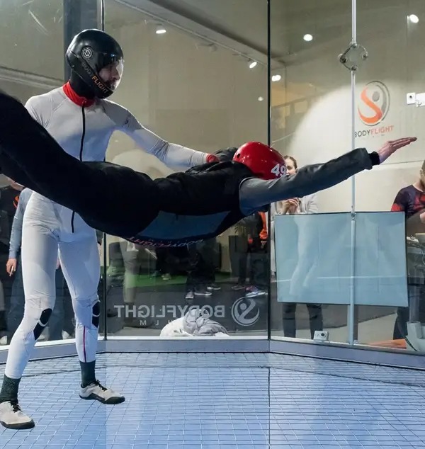 En man som kör indoor skydiving, en av många aktiviteter att göra i Stockholm.